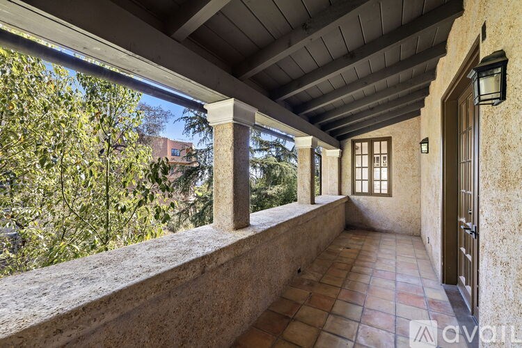 A balcony with a tiled floor and a wooden door.