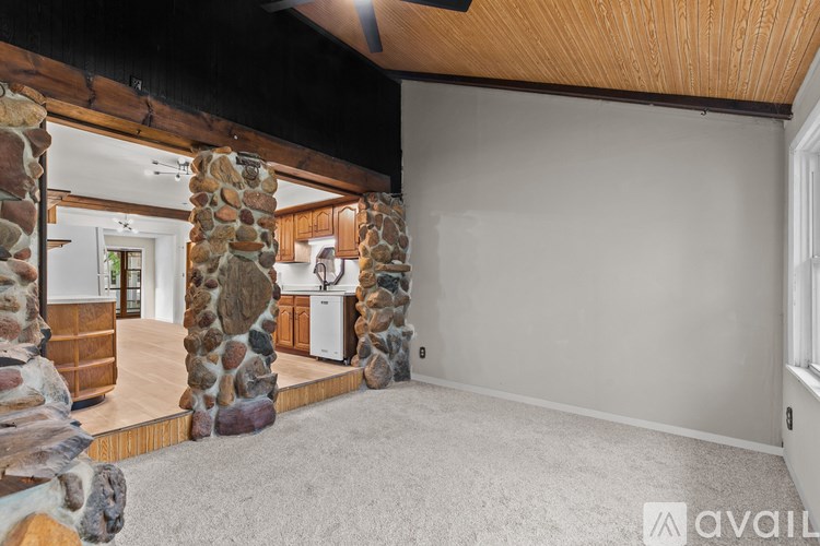 A room with stone pillars and a wooden ceiling.