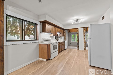 A kitchen with wooden cabinets and a white refrigerator.