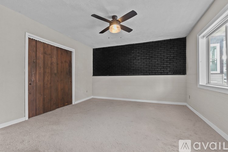 A room with a ceiling fan and a window.