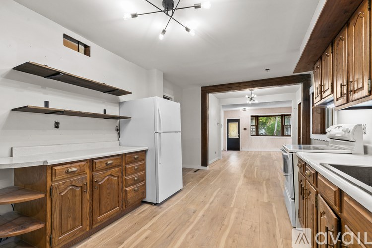 A modern kitchen with wooden cabinets and a white refrigerator.
