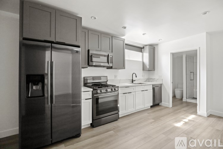 A modern kitchen with a refrigerator, stove, and microwave.
