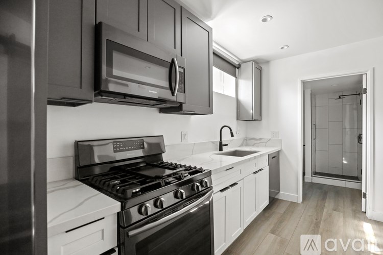 A modern kitchen with a stove, microwave, and oven.