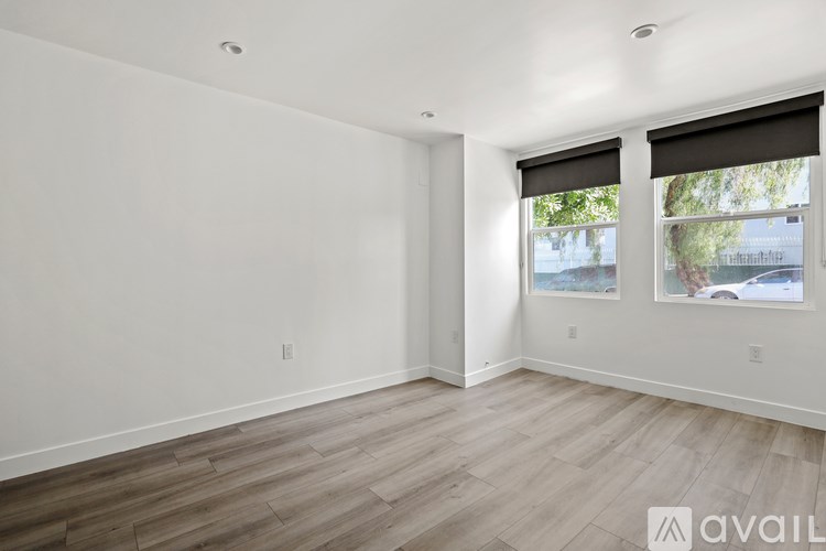 A room with wooden flooring and white walls.