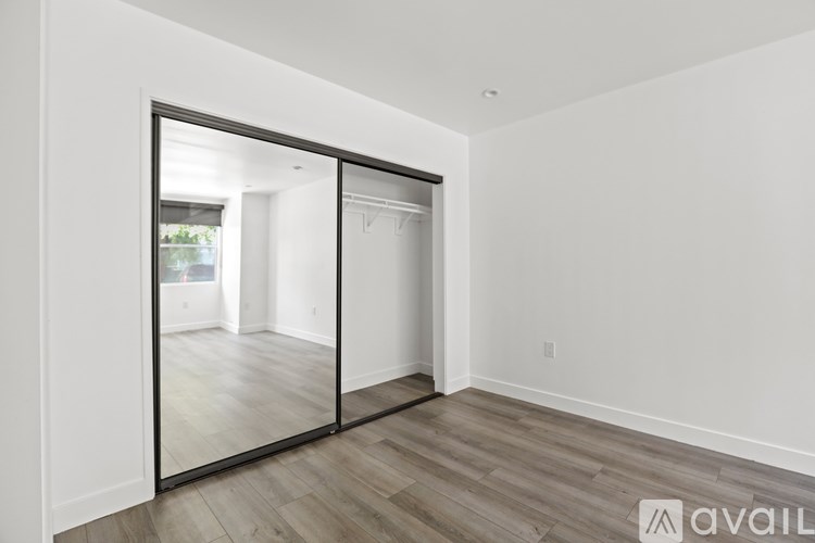A room with a sliding door and wooden flooring.