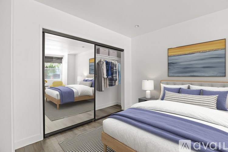 A bedroom with a bed, a mirror, and a painting on the wall.