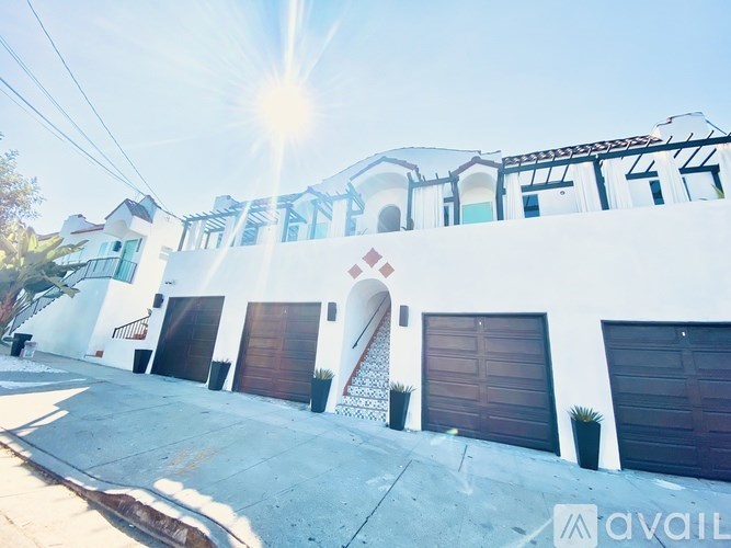 A white house with a brown garage door is for sale.