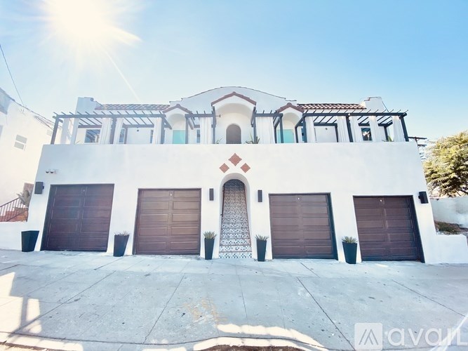 A white two-story house with a brown garage door.