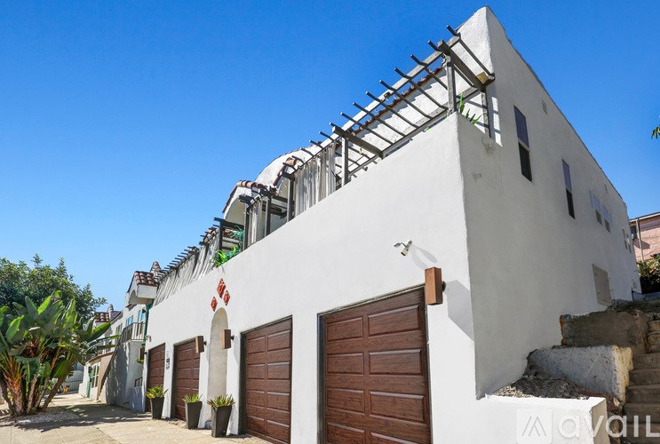 A white building with a brown door and windows.