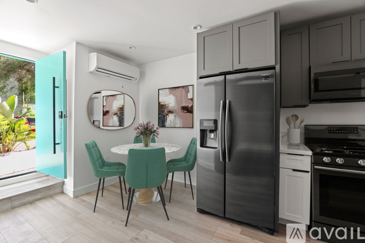 A kitchen with a table and chairs and a refrigerator.