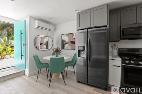 A kitchen with a table and chairs and a refrigerator.