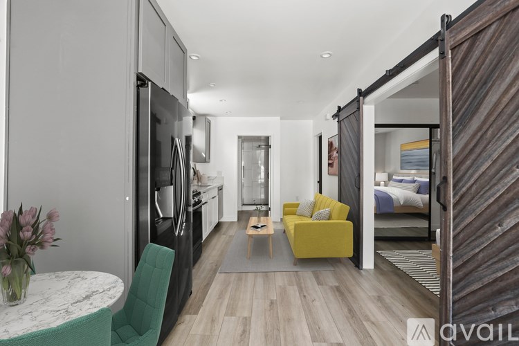 A modern kitchen with a dining table and a yellow sofa.