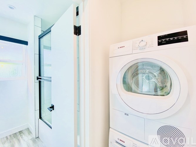 A white front loading washing machine in a room.