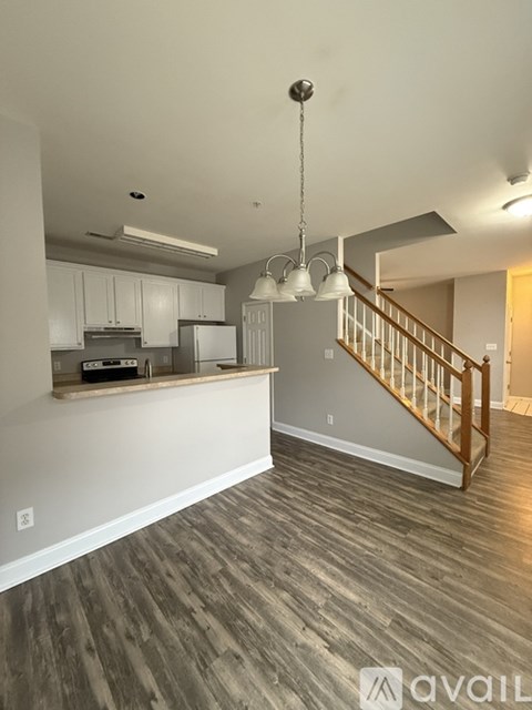 A kitchen with a staircase in the background.