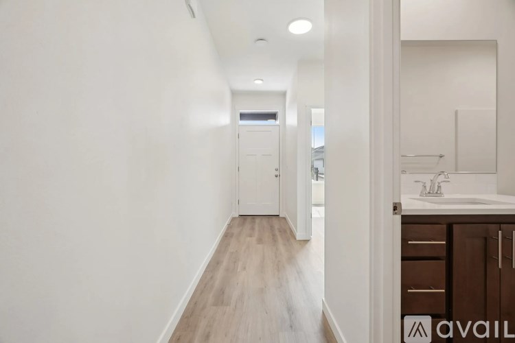 A long hallway with a sink and cabinet on the right.