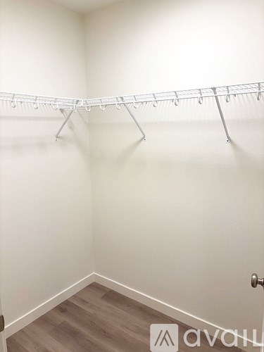 A white wall with a clothes rack and a door.