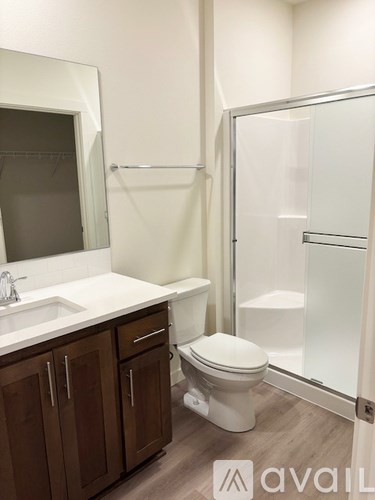 A bathroom with a toilet, sink, and shower.