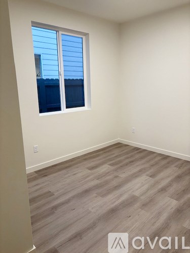A room with a window and wooden flooring.