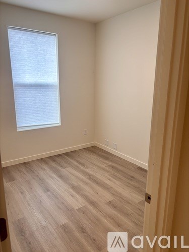 A room with a window and wooden flooring.