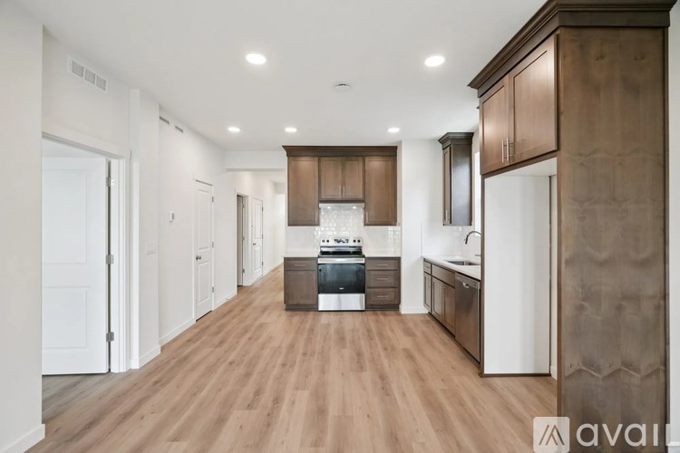 A modern kitchen with wooden floors and cabinets.