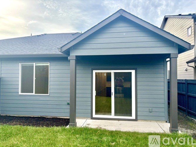 A small house with a grey roof and a white door.