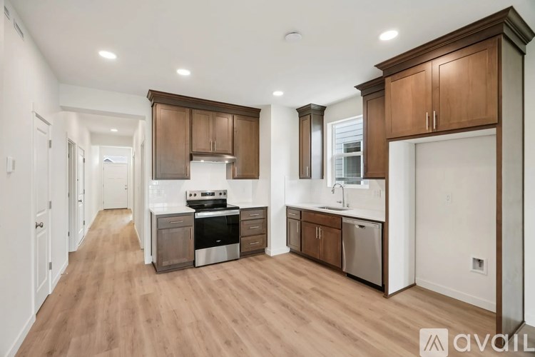 A kitchen with wooden cabinets and a stainless steel dishwasher.