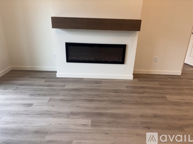 A room with a window and wooden flooring.