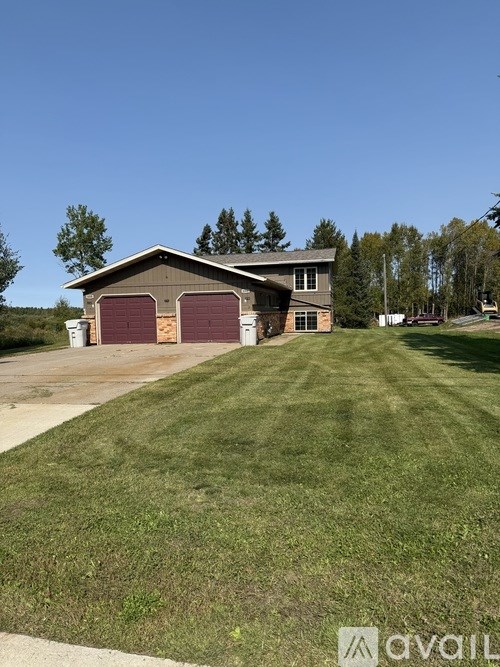 A two-story house with a garage and a driveway in front.