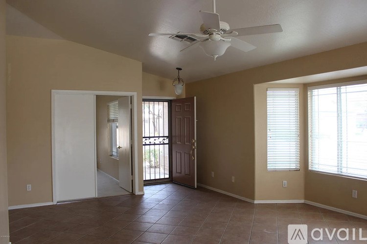 A room with a ceiling fan and tiled floor.