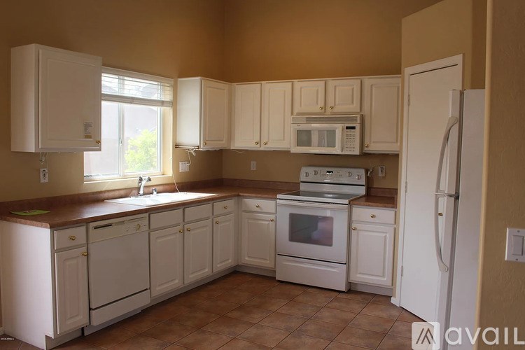 A kitchen with white cabinets and appliances.