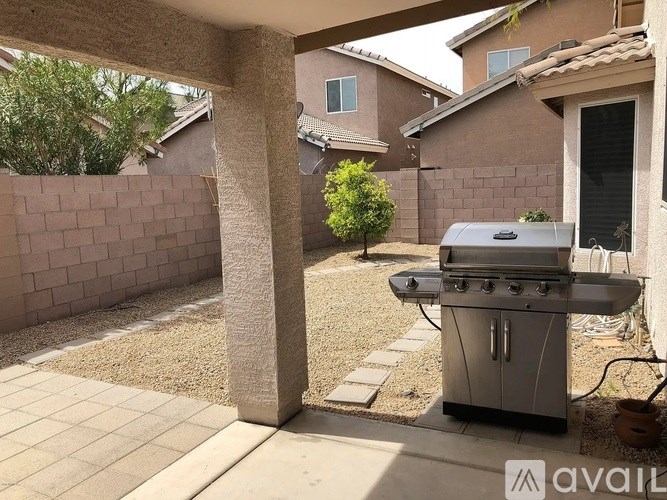 A patio with a grill and a wall.