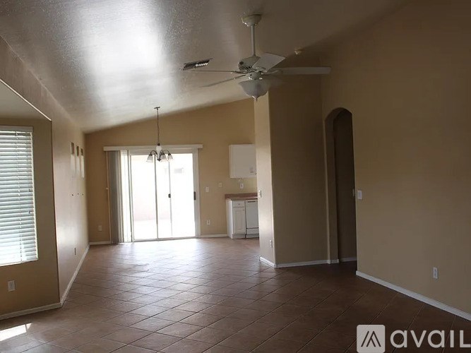 A spacious room with a ceiling fan and sliding glass doors.