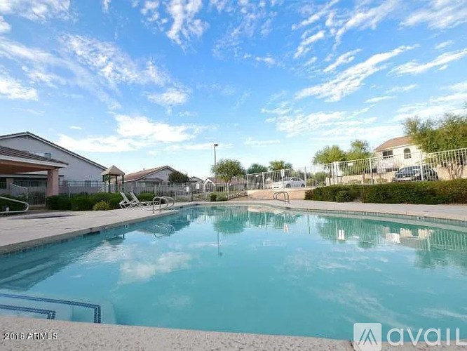 A swimming pool surrounded by a fence and a few houses.