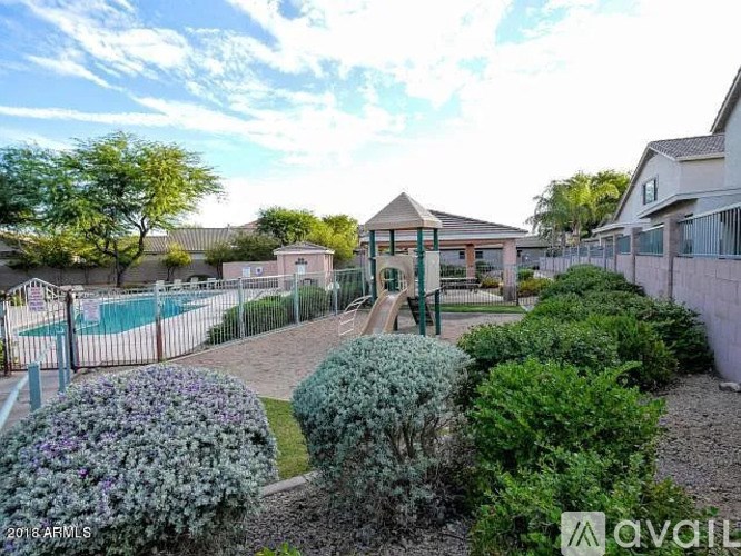 A playground with a slide and a fence in the foreground.