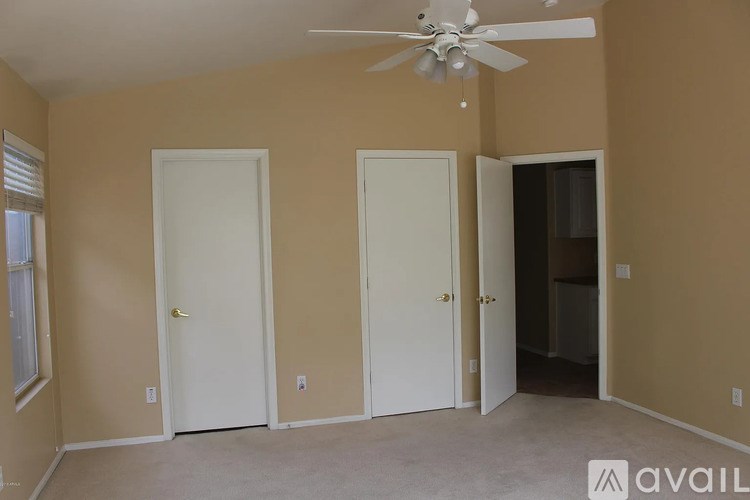 Three white doors in a room with beige walls.