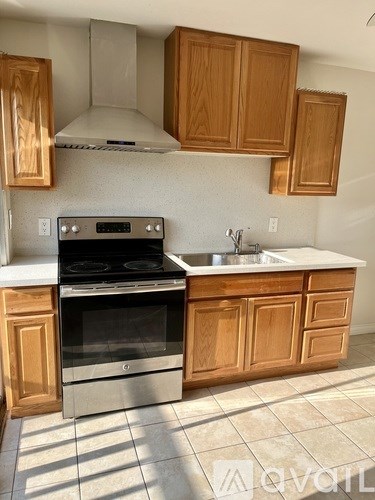 A kitchen with wooden cabinets and a stainless steel oven.