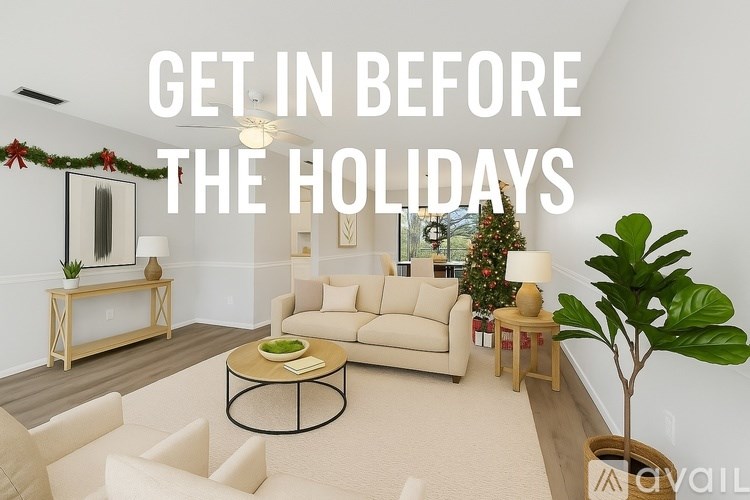A living room with a Christmas tree and a sign that says "Get in before the holidays".