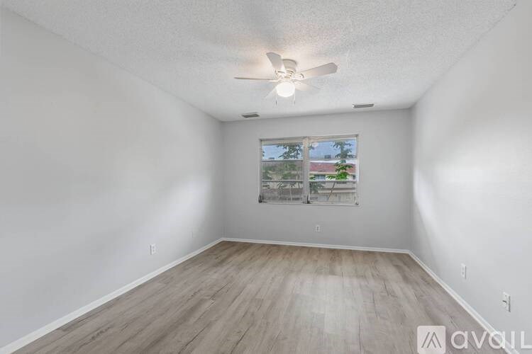 A room with a window and a ceiling fan.