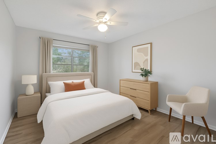 A bedroom with a bed, nightstand, chair, and window.