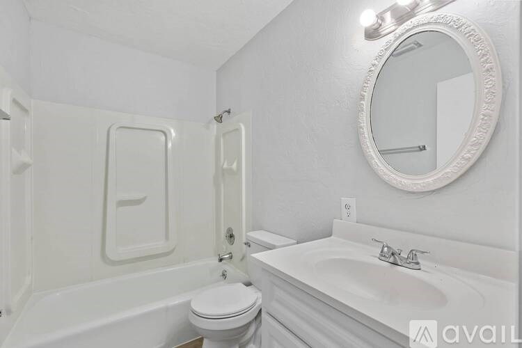 A white bathroom with a toilet, sink, and tub.