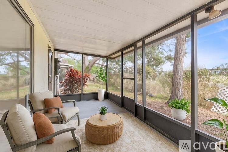 A sunny day in a room with a view of trees and plants outside.