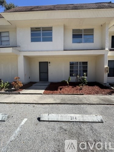 A white building with the number 314 painted on the ground in front of it.