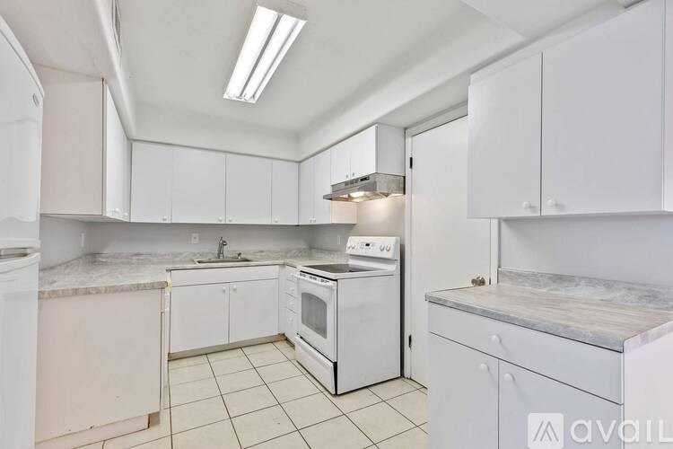 A kitchen with white cabinets and appliances.