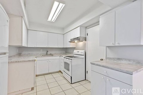 A kitchen with white cabinets and appliances.