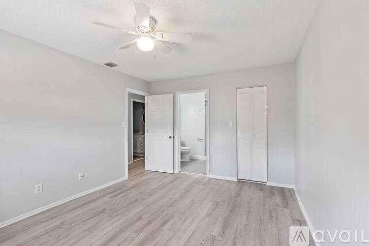 A room with a ceiling fan and light, and a doorway leading to another room.