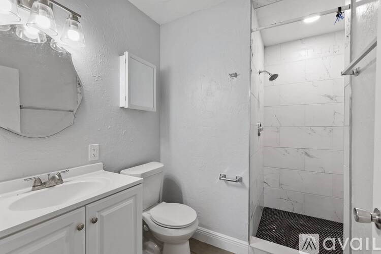 A bathroom with a toilet, sink, and shower.