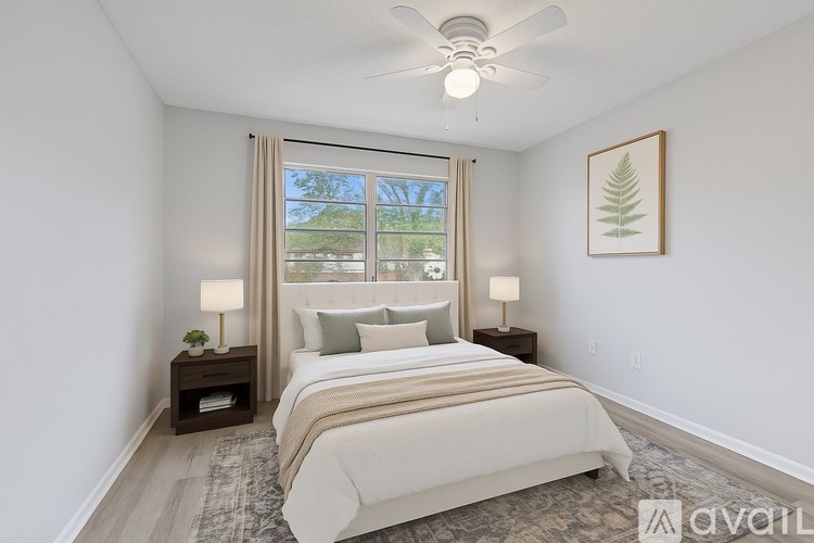 A bedroom with a large bed and a ceiling fan.