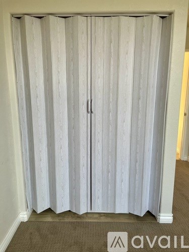 A room with a white curtain and a carpet.