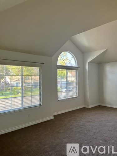 A room with a large window and a carpeted floor.