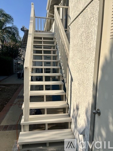 A white wooden staircase with a metal railing.